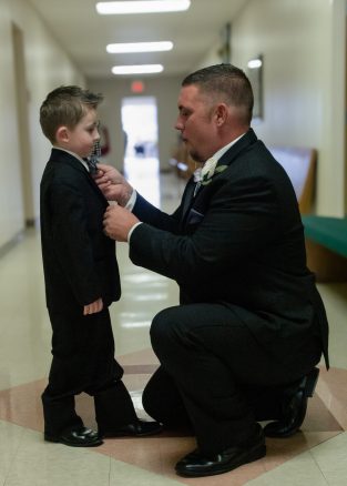 the groom fixing the ring bearers tie