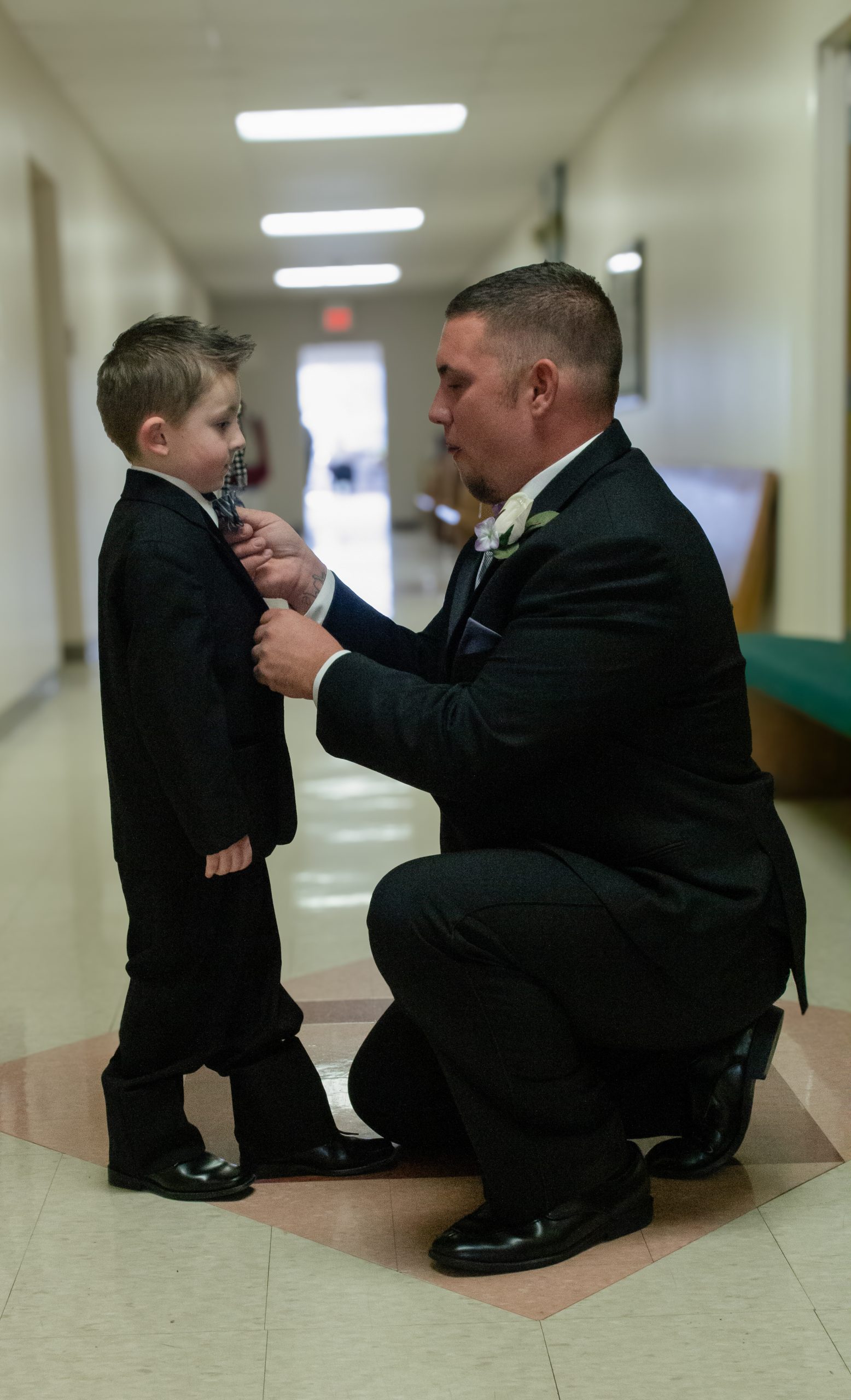 the groom fixing the ring bearers tie