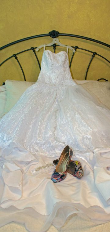 bride's gown and shoes on bed