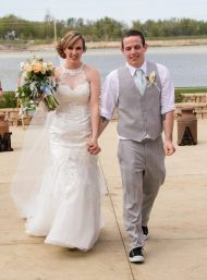 bride and groom recessional with a river behind them smiling