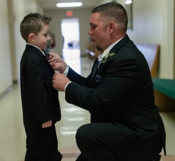 the groom fixing the ring bearers tie