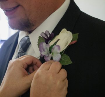 groom getting boutonniere pinned on