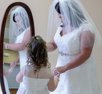 The bride and flower girl getting ready in front of mirror