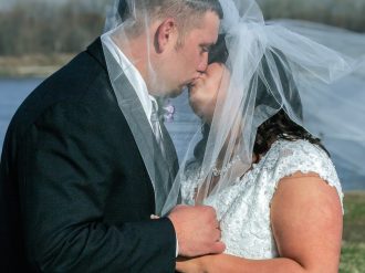 bride and groom kissing under veil