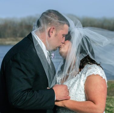 bride and groom kissing under veil
