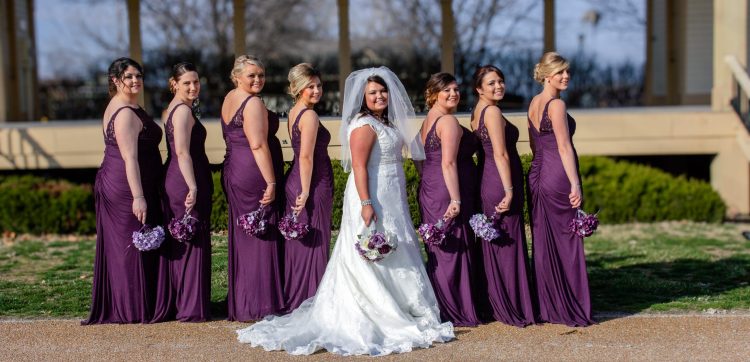 the bride and bridesmaids in a row smiling