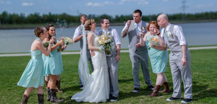 wedding party blowing bubbles at bride and groom