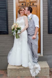 groom kissing bride on doorstep