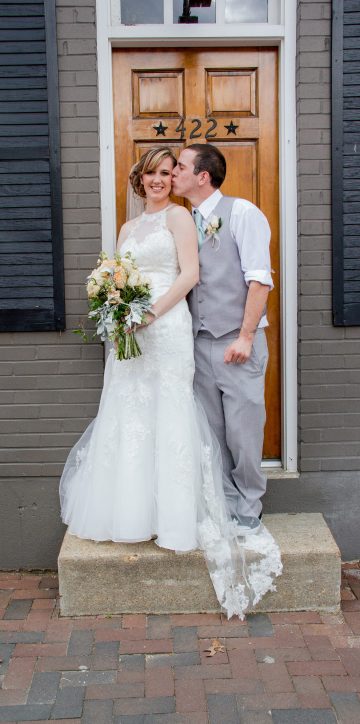 groom kissing bride on doorstep