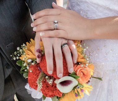 bride and grooms hands on beautiful bouquet