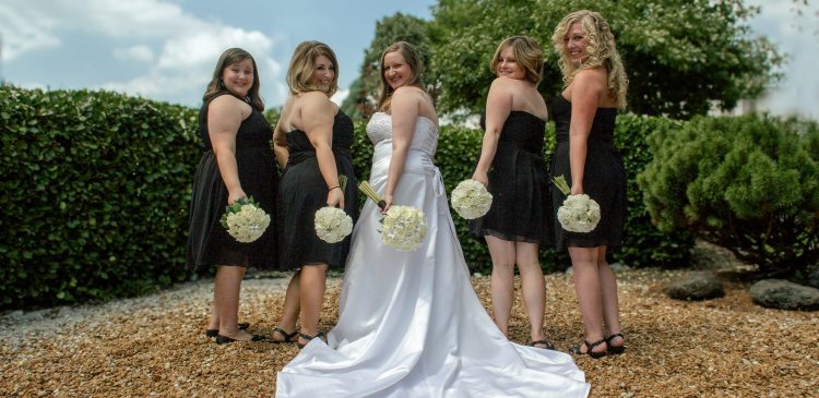 Bride and bridesmaids smiling over their shoulders