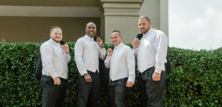 Groom and groomsmen with jackets over shoulder