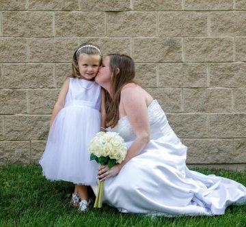 Bride kissing flower girl